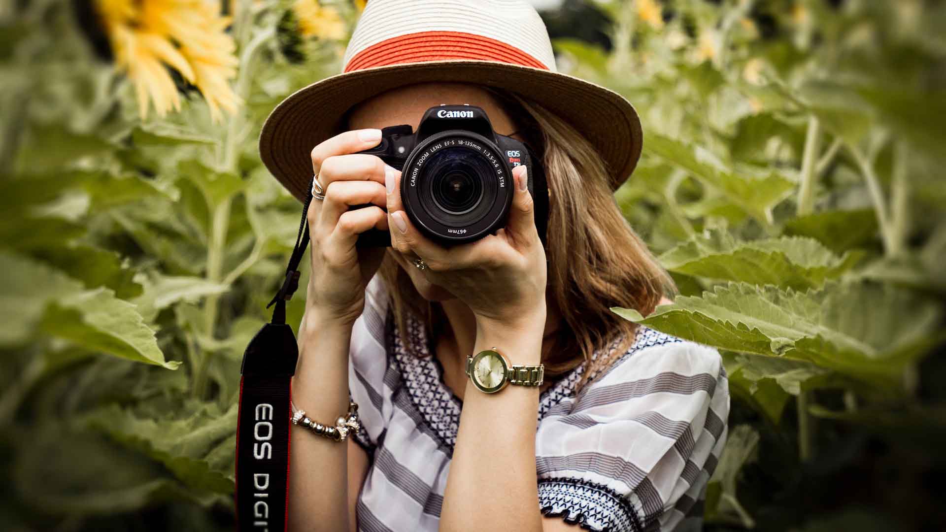 Девушка-фотограф с камерой в руках 