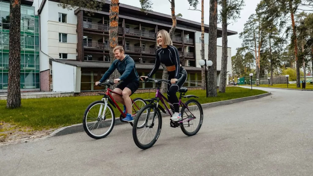 Молодая пара катается на велосипедах у корпуса